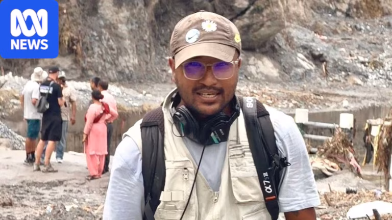 A man wearing a brown hat and glasses is seen with a camera in his hand